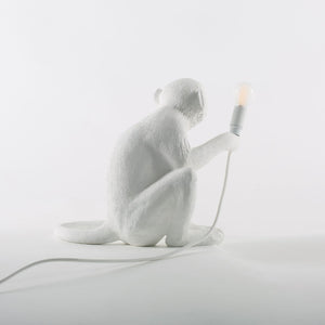 Sitting monkey holding a light, made from polyresin and hand finished in white. Approx 13” tall.