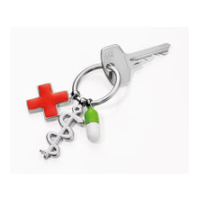 Troika keyring with red cross, pill, and Aesculapian staff charms.