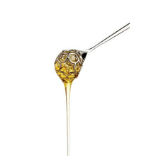 Stainless steel honey dipper in the shape of a honey comb.
